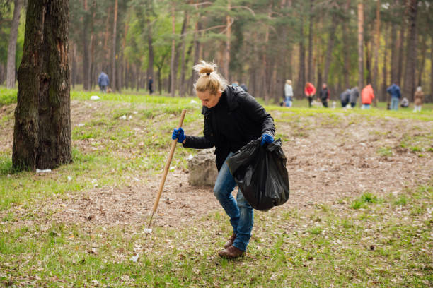 istock Woman volunteer collecting garbage in park 876321980