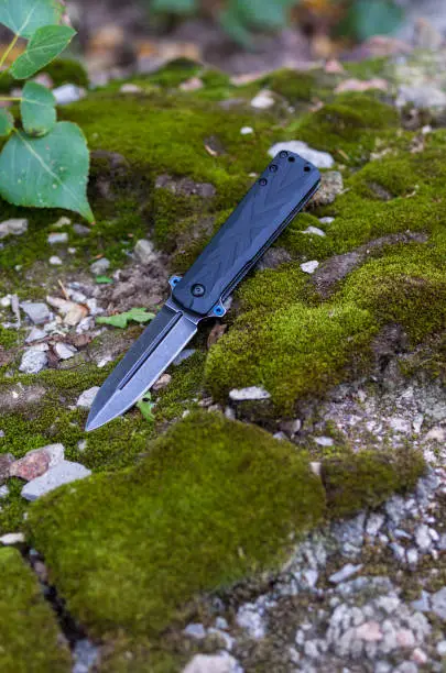 Photo of Pocket knife. Knife blade in the form of a spear. Vertical frame.
