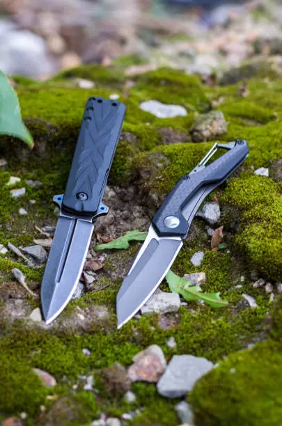 Photo of Two folding knives. Knives with different handles. Vertical frame.