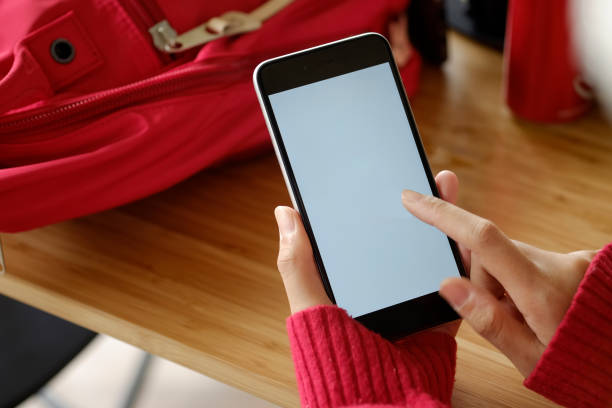 istock Woman hands holding empty screen of smartphone on wood desk work. 876343340