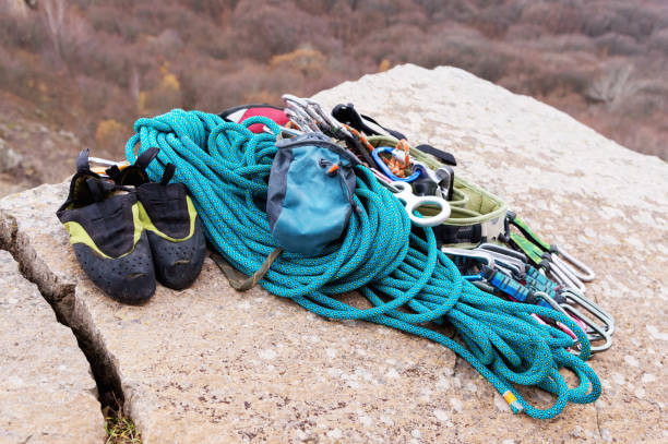istock Climbing equipment - rope and carbines view from the side close-up. A coiled climbing rope lying on the ground as a background. Concept of outdoor sport 876343768