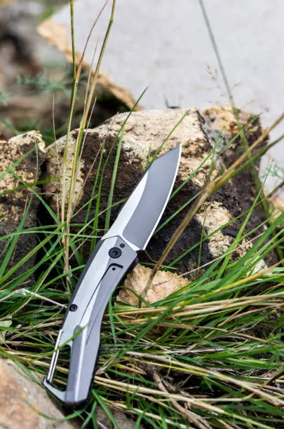Photo of Pocket knife with a carbine. Photo knife in nature.