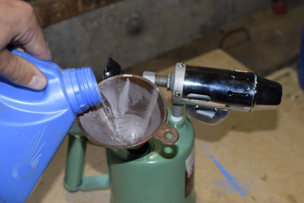istock Pouring gasoline blowtorch through the funnel 876350350