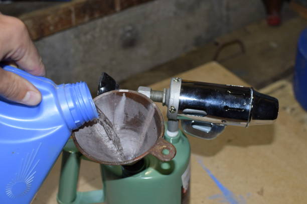 istock Pouring gasoline blowtorch through the funnel 876350360