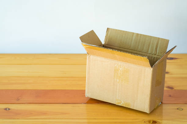istock Empty opened old brown cardboard box for mock up on the wooden table with copy space. 876359762