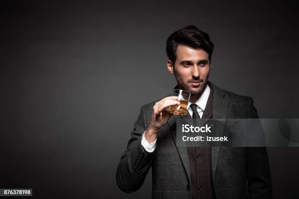 Portrait Of Handsome Man Drinking Whiskey Stock Photo - Download Image Now - Whiskey, Drinking, Men