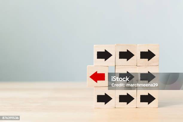 Wooden Block With Red Arrow Facing The Opposite Direction Black Arrows Unique Think Different Individual And Standing Out From The Crowd Concept Stock Photo - Download Image Now