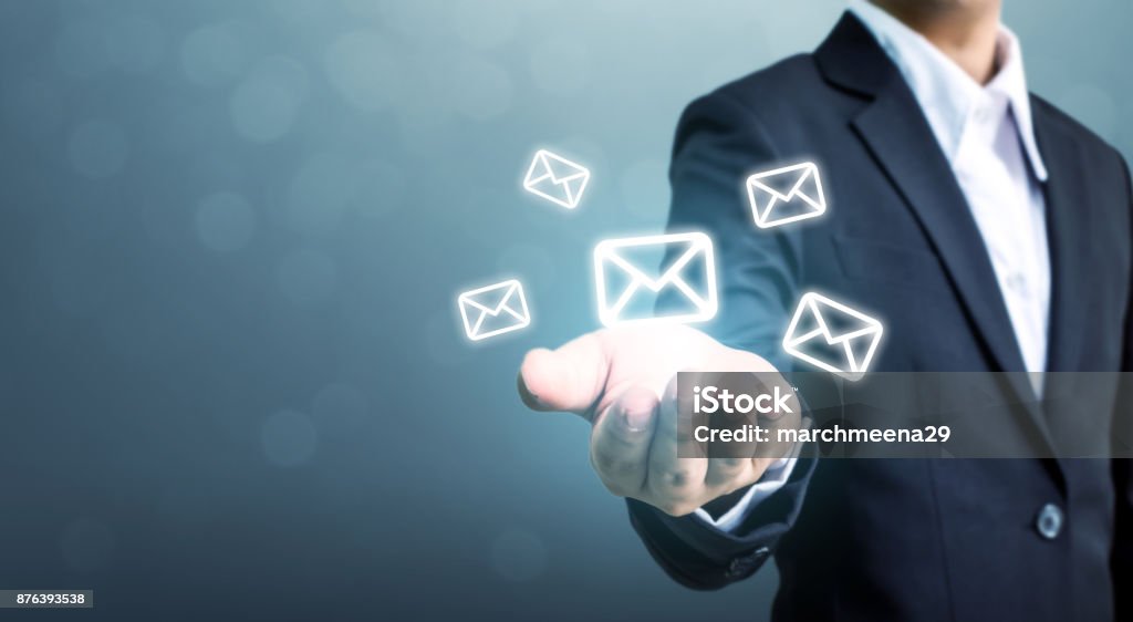 Businessman hand holding e-mail icon, Contact us by newsletter email and protect your personal information from spam mail concept E-Mail Stock Photo