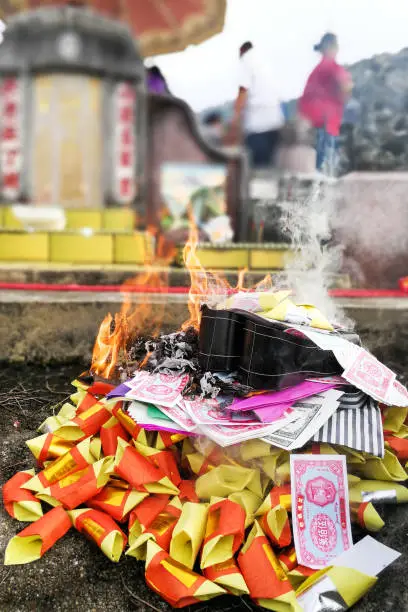 Chinese taoism tradition to burn paper money and gold to ancestors during Qingming or tomb sweeping day