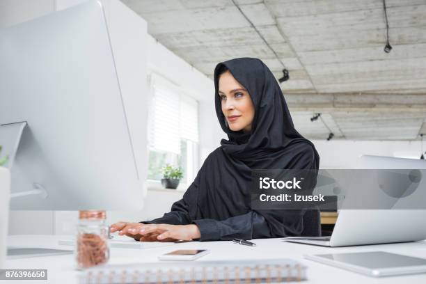 Muslim Woman Working At Her Office Desk Stock Photo - Download Image Now - Arabia, Islam, One Woman Only
