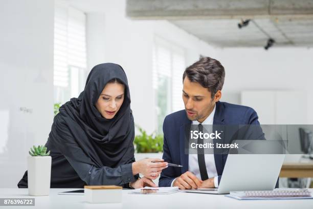 Businessman And Muslim Businesswoman Working On Project Stock Photo - Download Image Now