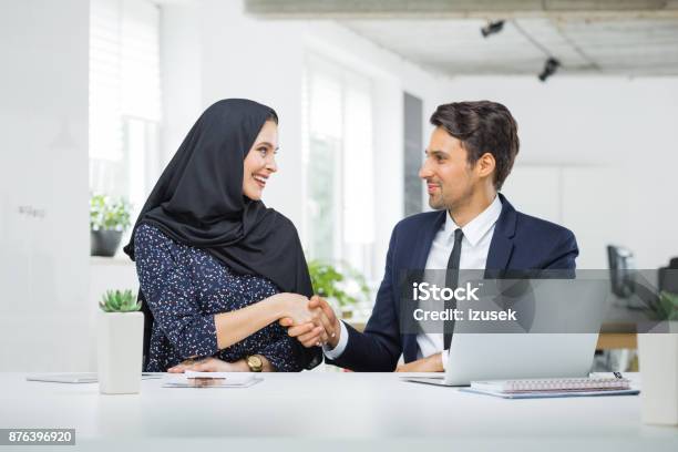Man And Muslim Woman Shaking Hands In Office Stock Photo - Download Image Now - Office, Arabia, Employee