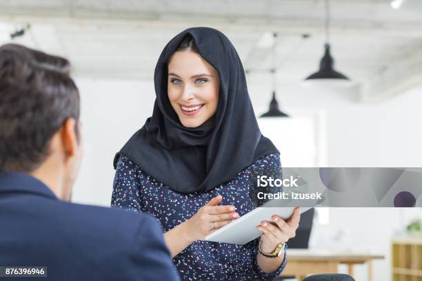 Muslim Businesswoman In Discussion With Colleague Stock Photo - Download Image Now - Digital Tablet, 20-29 Years, Adult