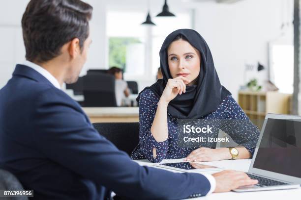 Muslim Businesswoman Working Listening To Male Colleague In Office Stock Photo - Download Image Now