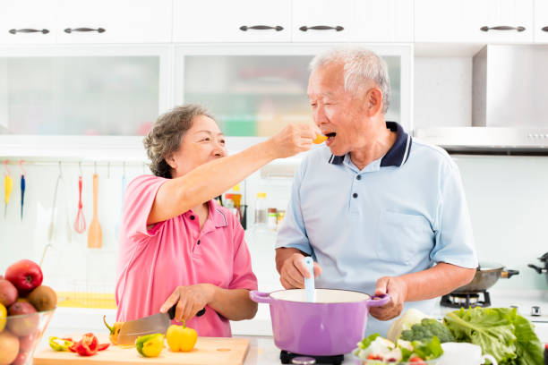 feliz casal sênior cozinhando na cozinha - healthy feeding - fotografias e filmes do acervo