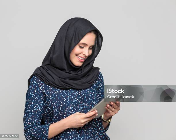 Smiling Muslim Woman Using Digital Tablet Stock Photo - Download Image Now - E-Reader, Reading, Adult