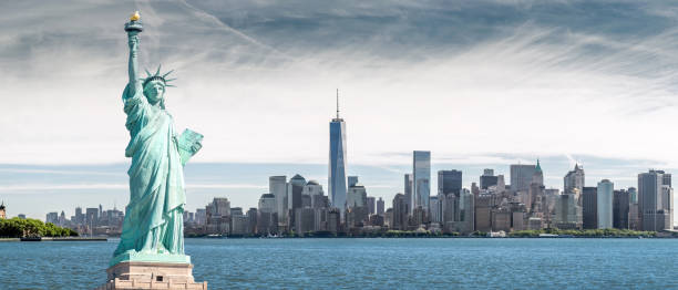 la statua della libertà con uno sfondo del world trade center, punti di riferimento di new york city - new york city panoramic statue of liberty skyline foto e immagini stock