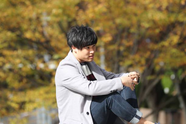 istock Young man sitting on fence 876403424