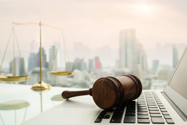 law legal technology law legal technology concept. Wooden gavel on laptop keyboard with scales of justice in business city background. lawsuit photos stock pictures, royalty-free photos & images