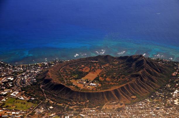 Diamond Head, An Aerial view of extinct volcanic crater in Hawaii Diamond head is a volcanic tuff cone on the Hawaiian island of Oʻahu and known to Hawaiians as Lēʻahi, most likely from lae 'browridge, promontory' plus ʻahi 'tuna' because the shape of the ridgeline resembles the shape of a tuna's dorsal fin. extinct volcano stock pictures, royalty-free photos & images