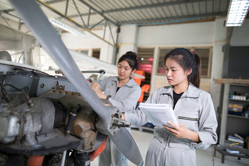 Asian women Engineers and technicians are repairing aircraft.