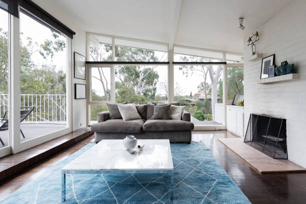 Mid century modern living room with huge windows to view the Australian treetops stock photo