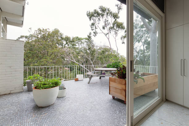 View of treetops from large mosaic tiled terrace in Australian luxury home stock photo