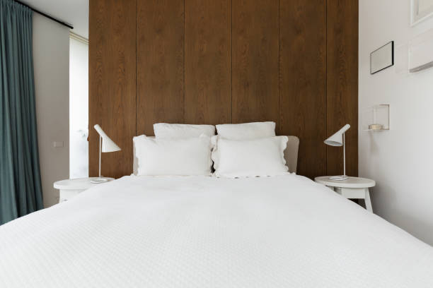 Luxury master bedroom with walnut wood panelling behind the bed