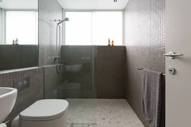 Photo of Modern walk in shower with mosaic full height tiles and terrazzo floor