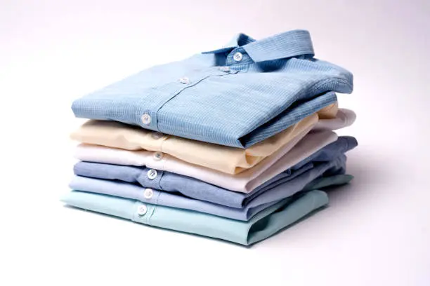 Photo of Classic men's shirts stacked on white background