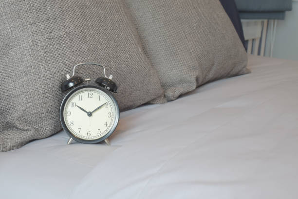 istock Retro style clock on brown color scheme bedding 876424460