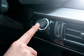 Finger press button functions car engine start and stop in motor vehicle for pre start checklist concept. Modern car interior details. Soft lighting