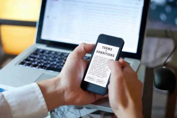 terms and conditions, man reading agreement on the screen of smartphone