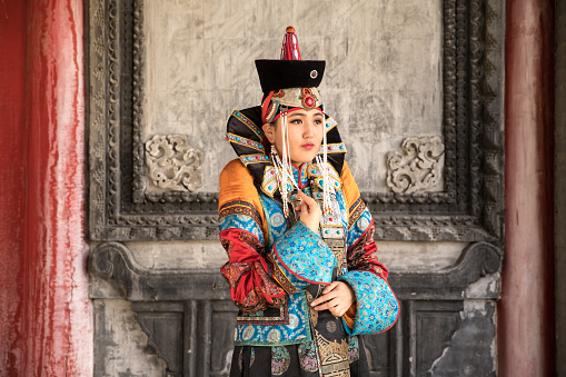 Young Mongolian woman in a traditional 13th century costume in a temple. Ulaanbaatar, Mongolia.