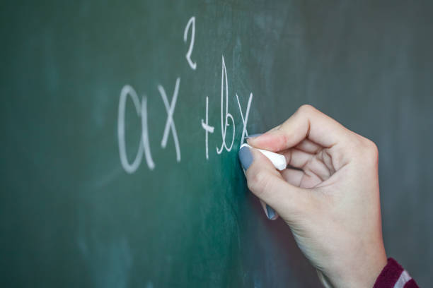 istock girl with chalk in her hand solves a mathematical problem on the blackboard 876457282