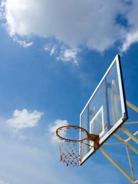 istock Old basketball hoop with backboard against  blue sky, white cloud 876457288