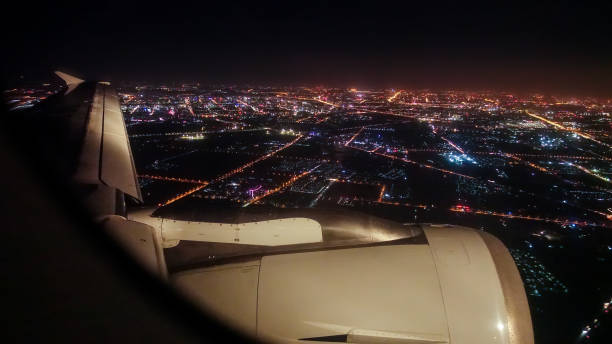 istock Airplane wing over city night 876478378