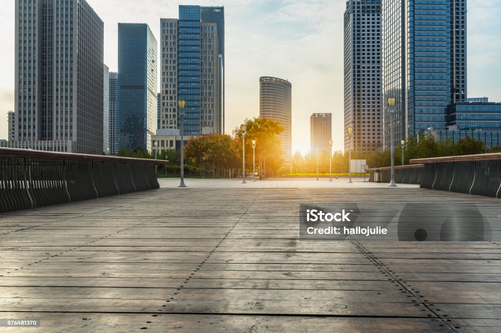 Empty wooden footpath front modern building at dusk Building Exterior, Built Structure, City, City Street, Cityscape City Stock Photo