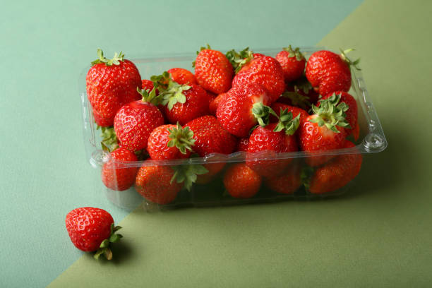 istock strawberries in box on green background, food closeup 876486208