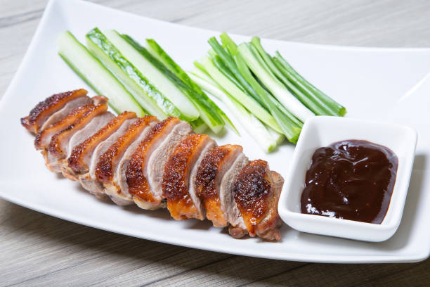 Baked duck with hoisin sauce, cucumbers and shallots. Baked duck with hoisin sauce, cucumbers and shallots. Selective focus, close-up. hoisin sauce stock pictures, royalty-free photos & images