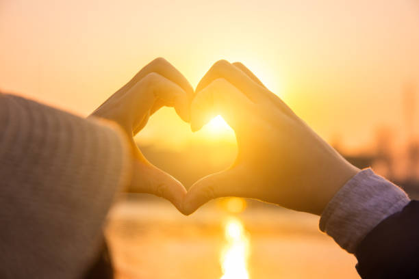 istock Woman making a hand shaped heart at sunset 876487402