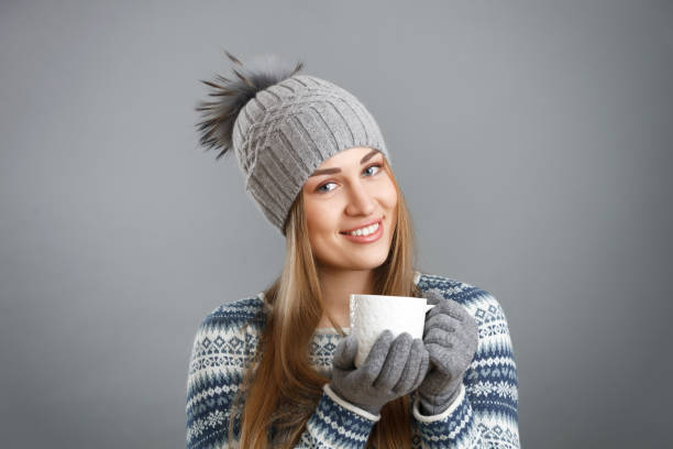 istock Beautiful smiling girl holding a cup with a hot drink. 876489990