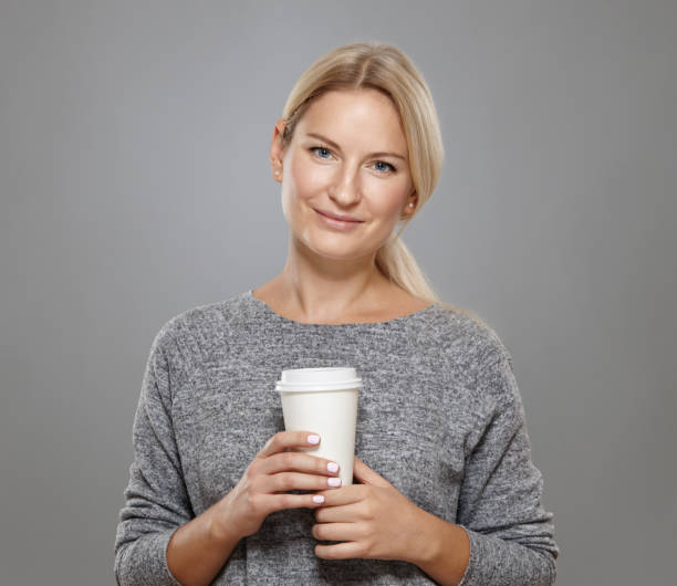 istock Attractive  woman is holding a cup coffee. 876490022