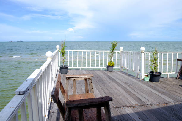 istock Tables and chairs on the porch that extends forward into the sea 876493216