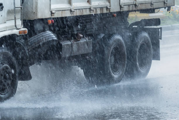 Rainwater spraying from motion truck wheels. city road during heavy rain.Thailand. Rainwater spraying from motion truck wheels. city road during heavy rain.Thailand truck rain stock pictures, royalty-free photos & images
