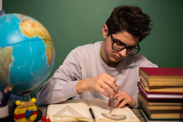 istock Education concept. Portrait of child with learning difficulties. Tired boy doing home assignment. 876497136