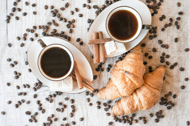 istock coffee grains with coffee cup and croissant 876503602