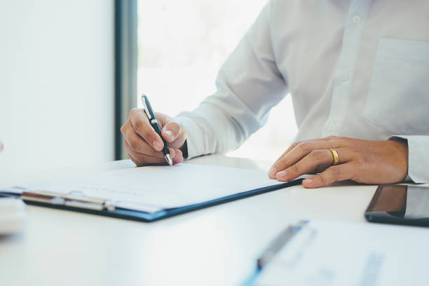 istock Signing a car insurance policy, the agent is holding the document 876509118