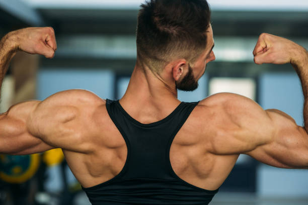 istock Young athlete posing with a torso for photography on a brick wall background. Bodybuilder, athlete with pumped muscles, breast and arm rescue. man 876511500