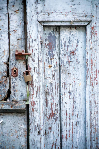 istock Old wooden blue door with lock, padlock  and latch. 876511820